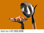 Чёрные руки ведьмы с приготовленными пальцами и клобук на оранжевом фоне. Празднование Хэллоуина. Стоковое фото, фотограф Pixel_shot / Фотобанк Лори
