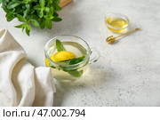 Чашка свежего чая с мятой, лимоном и медом на потертом светлом столе. Стоковое фото, фотограф Pixel_shot / Фотобанк Лори