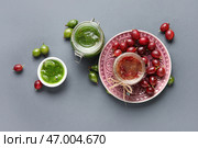 Банки и миска с вкусным вареньем из крыжовника на сером фоне. Стоковое фото, фотограф Pixel_shot / Фотобанк Лори