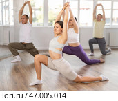 Group of sports multinational people practicing synchronous group choreography in dance studio. Стоковое фото, фотограф Яков Филимонов / Фотобанк Лори