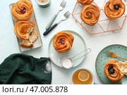 Вкусные краффины и чашка чая с лимоном на белом фоне. Стоковое фото, фотограф Pixel_shot / Фотобанк Лори