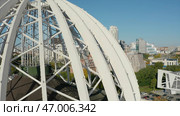 Dome made of metal semi-arches with air space on background of modern city. Стоковое фото, фотограф David Kashakhi / Фотобанк Лори