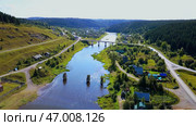 Arial view of a small town crossed by a river with a bridge. Стоковое фото, фотограф David Kashakhi / Фотобанк Лори
