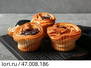 Деревянная доска с вкусными круффинами с шоколадом на сером фоне. Стоковое фото, фотограф Pixel_shot / Фотобанк Лори