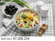 Миска салата с крабовыми палочками, кукурузой и огурцом на сером фоне. Стоковое фото, фотограф Pixel_shot / Фотобанк Лори