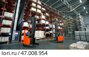Serbia - Belgrade, September 20, 2022: Goods lay on shelves in large warehouse with loaders at factory. Редакционное фото, фотограф David Kashakhi / Фотобанк Лори