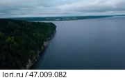 Aerial view of a forested cliff and the large blue lake. Стоковое фото, фотограф David Kashakhi / Фотобанк Лори