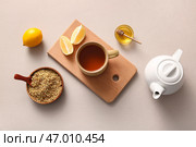 Чашка и чайник с горячим гречишным чаем с лимоном и миска с мёдом на сером фоне. Стоковое фото, фотограф Pixel_shot / Фотобанк Лори