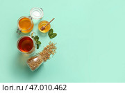 Стакан горячего гречишного чая с мятой и банка меда на бирюзовом фоне. Стоковое фото, фотограф Pixel_shot / Фотобанк Лори
