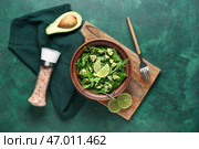 Миска вкусного авокадо-салата с лаймом и кунжутными семенами на зеленом фоне. Стоковое фото, фотограф Pixel_shot / Фотобанк Лори