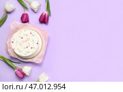 Сладкий бенто-торт и красивые тюльпаны на лиловом фоне. Международный женский день. Стоковое фото, фотограф Pixel_shot / Фотобанк Лори