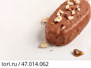 Вкусное мороженое, покрытое шоколадом и измельченными орехами на белом столе, крупный план. Стоковое фото, фотограф Pixel_shot / Фотобанк Лори