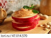 Деревянная доска с ломтиками яблока, ореховым маслом, арахисом и листьями мяты, крупным планом. Стоковое фото, фотограф Pixel_shot / Фотобанк Лори