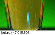 Yellow alcohol drink inside transparent glass. Стоковое фото, фотограф David Kashakhi / Фотобанк Лори