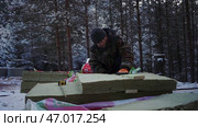 Man cuts materials for building house in forest in winter. Стоковое фото, фотограф David Kashakhi / Фотобанк Лори
