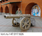 Туристка позирует у реконструкции старинного двуствольного артиллерийского орудия. Культурно-исторический комплекс «Царевококшайский Кремль».  Йошкар-Ола, Вознесенская ул., 58 (2020 год). Редакционное фото, фотограф Алексей Иванов / Фотобанк Лори