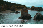Rocks and ledges on seashore with seagulls on background of cloudy horizon. Стоковое фото, фотограф David Kashakhi / Фотобанк Лори