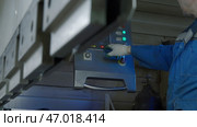 Operator pressing buttons on control panel of an industrial machine. Стоковое фото, фотограф David Kashakhi / Фотобанк Лори