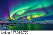 Northern Lights on the shore of a crystal lake and mountainous landscape. Colorful lights in the sky at low temperatures. Стоковое AI-изображение, AI-художник Антон Слабоспицкий / Фотобанк Лори