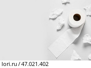 Рулон туалетной бумаги и скомканные простыни на сером фоне. Стоковое фото, фотограф Pixel_shot / Фотобанк Лори