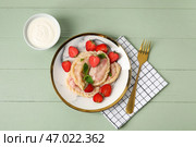 Тарелка с вкусными клубничными клецками и соусом на цветном деревянном фоне. Стоковое фото, фотограф Pixel_shot / Фотобанк Лори