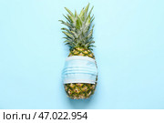 Свежий ананас в медицинской маске на цветном фоне. Стоковое фото, фотограф Pixel_shot / Фотобанк Лори