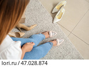 Молодая женщина примеряет новую обувь в современном магазине. Стоковое фото, фотограф Pixel_shot / Фотобанк Лори