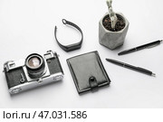 Стильная композиция с фитнес-трекером и фотоаппаратом на белом фоне. Стоковое фото, фотограф Pixel_shot / Фотобанк Лори