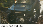 Off-road vehicle prepared for serious off-roading, with the help of a winch overcomes difficult terrain. The vehicle has large wheels with aggressive tread. Стоковое фото, фотограф Воловодов Владимир / Фотобанк Лори