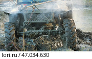 Close-up of the front part of an off-road vehicle prepared for heavy off-roading, immersed in mud. The car is covered in mud, steam is rising from under the hood. Стоковое фото, фотограф Воловодов Владимир / Фотобанк Лори