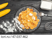 Тарелка вкусных блинов и банана на темном деревянном фоне. Стоковое фото, фотограф Pixel_shot / Фотобанк Лори