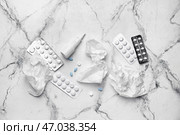 Флакон с каплями, таблетками и использованными салфетками на светлом фоне. Стоковое фото, фотограф Pixel_shot / Фотобанк Лори