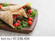 Доска с вкусной фалафельной питой на светлом фоне. Стоковое фото, фотограф Pixel_shot / Фотобанк Лори