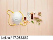 Композиция из бутылочек капель, цветов и респиратора на цветном деревянном фоне. Стоковое фото, фотограф Pixel_shot / Фотобанк Лори