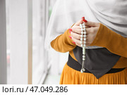 Мусульманка с тасби у окна, крупным планом. Стоковое фото, фотограф Pixel_shot / Фотобанк Лори