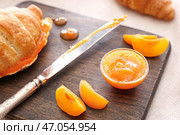 Вкусное абрикосовое варенье с круассаном на деревянной доске, крупным планом. Стоковое фото, фотограф Pixel_shot / Фотобанк Лори