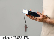 Религиозный человек молится Богу на сером фоне. Стоковое фото, фотограф Pixel_shot / Фотобанк Лори