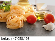 Сырые феттучини паста и продукты на столе. Стоковое фото, фотограф Pixel_shot / Фотобанк Лори