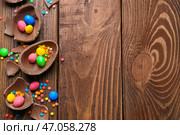Шоколадные пасхальные яйца с конфетами и брызгает на деревянном фоне, вид сверху. Стоковое фото, фотограф Pixel_shot / Фотобанк Лори
