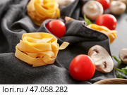 Сырые феттучини паста и продукты на столе. Стоковое фото, фотограф Pixel_shot / Фотобанк Лори