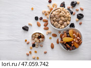 Чаши с различными вкусными орехами и сухофруктами на деревянном столе. Стоковое фото, фотограф Pixel_shot / Фотобанк Лори