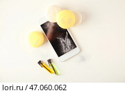 Вкусные макаруны с телефона на белом фоне. Стоковое фото, фотограф Pixel_shot / Фотобанк Лори