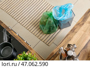 Очистить корзину для мусора и заменить полный мешок в кухне. Стоковое фото, фотограф Pixel_shot / Фотобанк Лори