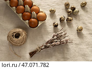 Куриные коричневые яйца в картонной упаковке и ветки вербы (ивы)  на льняной скатерти. Стоковое фото, фотограф Оксана Шведкова / Фотобанк Лори