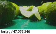Fresh Limes Resting on a Reflective Surface Accompanied by Brightly Colored Slices. Стоковое видео, видеограф Владимир Ковальчук / Фотобанк Лори