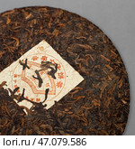 Authentic Compressed Puerh Tea Cake featuring a Traditional and Beautiful Wrapper design. Стоковое фото, фотограф David Kashakhi / Фотобанк Лори