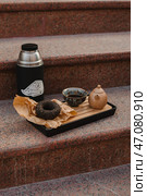 Im enjoying a relaxing tea time with a delicious donut and thermos on cozy steps. Стоковое фото, фотограф David Kashakhi / Фотобанк Лори