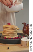 A pile of pancakes is topped with succulent, fully ripened red berries. Vertical. Стоковое видео, видеограф Strunov David / Фотобанк Лори