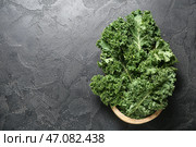 Деревянная миска со свежими листьями капусты кейл на черном фоне. Стоковое фото, фотограф Pixel_shot / Фотобанк Лори