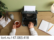 Женщина-писательница с чаем печатает на пишущей машинке за столом в офисе, вид сверху. Стоковое фото, фотограф Pixel_shot / Фотобанк Лори